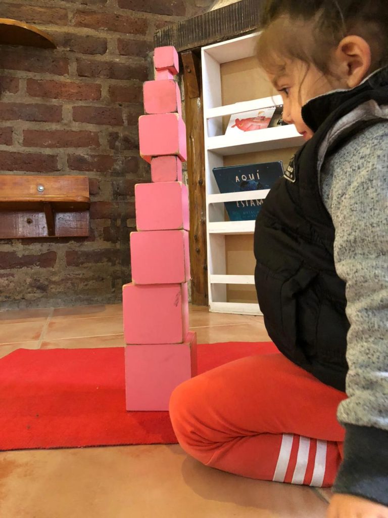 Niña de la institución jugando con piezas de madera